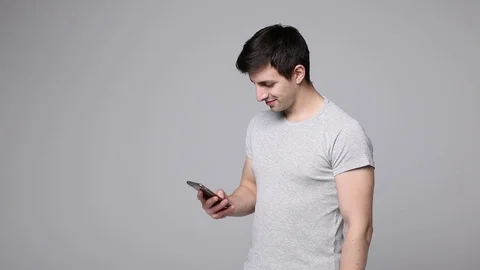 Young man holding phone and scroll screen after typing message Stock Footage
