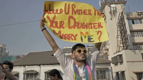 A young man holding a placard with message and blowing kisses at crowd Stock Footage 86138853