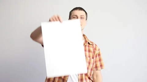 Young man holding a sheet of paper and indication to it Stock Footage 60408010