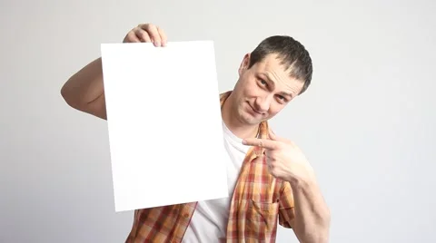 Young man holding a sheet of paper and indication to it Stock Footage 60408036
