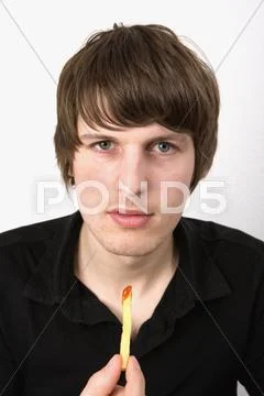 Young man holding a single french fry dipped in ketchup Stock Photos
