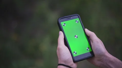 Young Man Holding Smartphone with empty green screen, outdoors Video stock 89984771