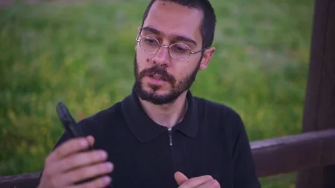 Young Man Holding Smartphone with empty green screen, outdoors Video stock 89984817