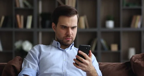Young man holding smartphone read bad message feels annoyed Stock Footage 155918104