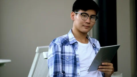 Young man holding tablet in hand and looking camera Stock Footage 106550233