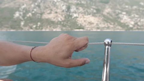 Young Man Holds Onto Railing Of Moving Boat Stock Footage 105974818