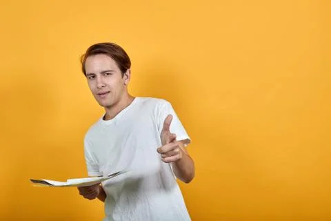 Young man holds several documents in hand and points the direction with finger Stock Photos