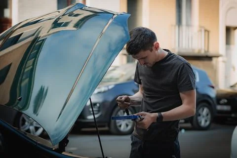 A young man holds tools for auto repair. Stockfoto's