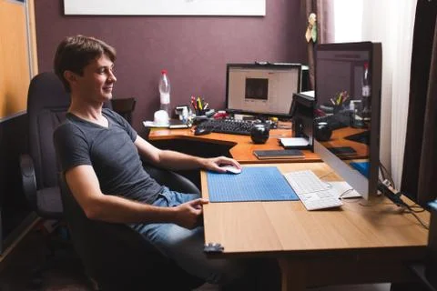 Young man at home using a computer, freelance developer or designer working Foto stock