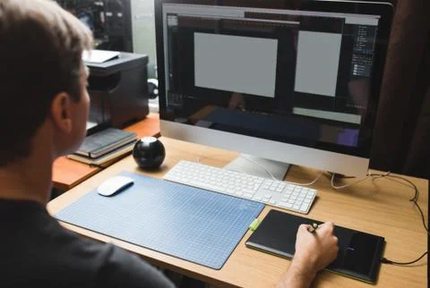 Young man at home using a computer, freelance developer or designer working Foto stock