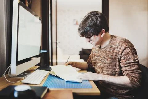 Young man at home using a computer, freelance developer or desig 写真素材
