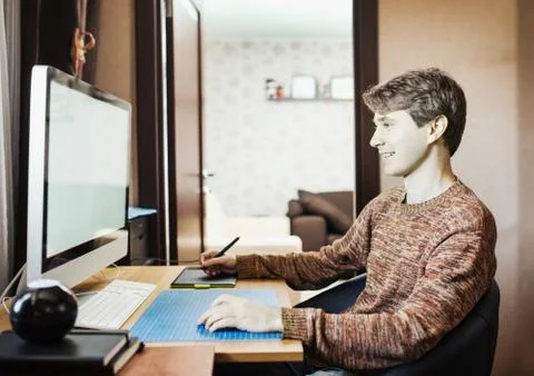 Young man at home using a computer, freelance developer or desig Foto stock