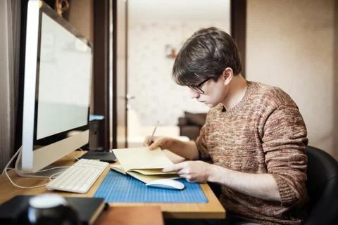 Young man at home using a computer, freelance developer or desig Stockfoto's