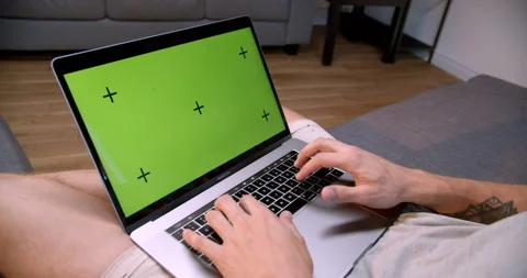 Young man at home using green mock-up screen laptop computer while sitting Stock Footage 170634450