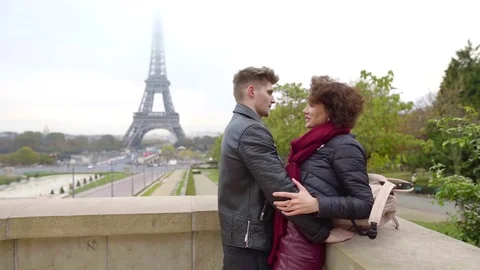 Young man is hugging his beloved cheerful girlfriend near famous parisian Stock Footage 98810626