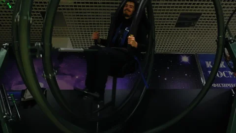 Young man in human gyroscope that simulates the training of the astronaut. Stock Footage 112760124