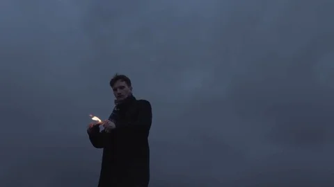 Young man Igniting and throwing Molotov bottle cocktail storm clouds background Stock Footage 74364072