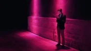 Young Man Illuminated By Multicolor Neon Light Using Smartphone At Night Stock Footage