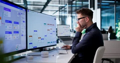 Young Man Improving Business Workflow On Computer With Automated Software Too Stock Photos