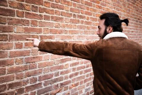 Young man indicates wall Stock Photos