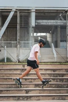 Young man inline skating down concrete stairs Stock Photos