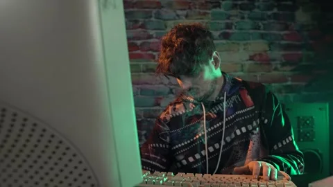 Young Man Inserting CD From Box Into Desktop Computer From 1990's. Dark Room Stock Footage 302972444