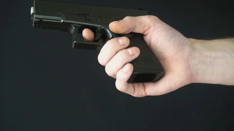 Young man inserts the clip into gun black. slow motion Stock-Footage 77065753