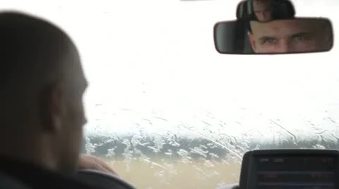 Young man inside car in the rain, mirror portrait. Stock Footage 11520046