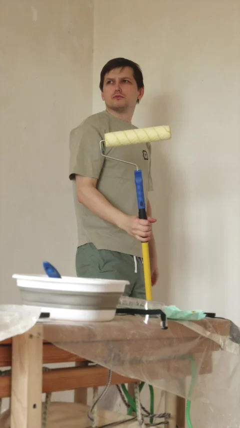 Young man inspecting freshly primed ceiling after finishing work Stock Footage 340405003