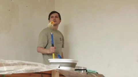 Young man inspecting primed ceiling after finishing renovation work Stock Footage 340403920