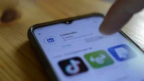 Young man install and download linkedin app on his smartphone. download app Stock Footage 179529338