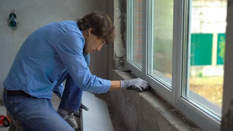 Young man installing windowsills of a plastic window Stock Footage 95544251