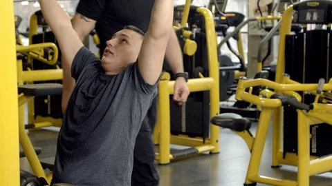 Young man with instructor working out in gym Stock Footage 125532931