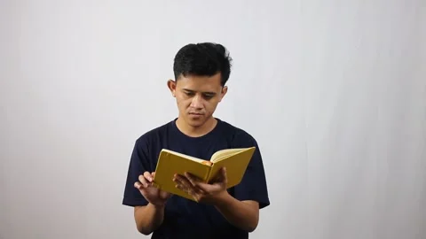 Young man intently reading book Stock Footage 314931897