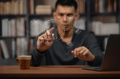 Young Man Interacting with Virtual Touchscreen Interface in Bookstore or Li.. Stock Photos