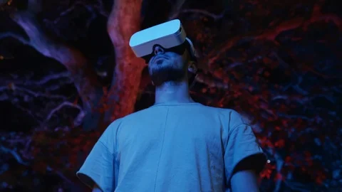 Young man interacts with virtual reality interface using VR headset gadget Stock Footage 107128027