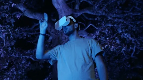 Young man interacts with virtual reality interface using VR headset gadget Stock Footage 107130130
