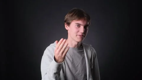 Young Man Inviting to Join Him on black Background Stock Footage 257475548