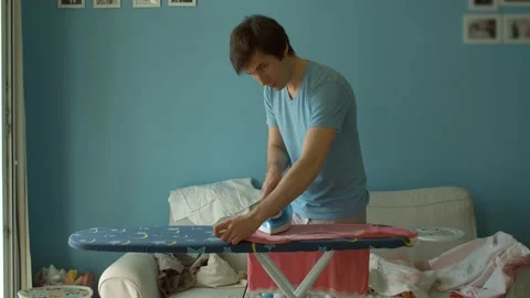 Young man ironing clothes Stock Footage 130994241