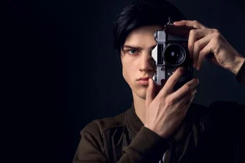 Young man isolated on a grey wall studio concept taking photos Stock Photos