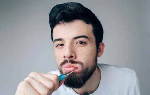 Young man isolated over background. Portrait of guy cleaning teeth with 스톡 사진