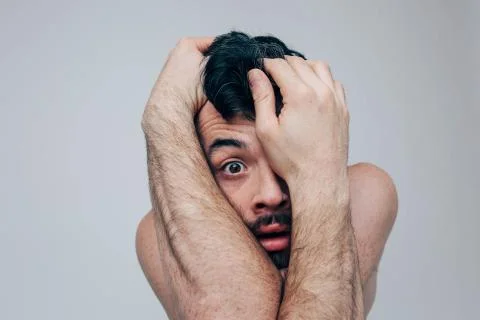 Young man isolated over background. Unbalanced mentally an disordered guy look Stock-Fotos