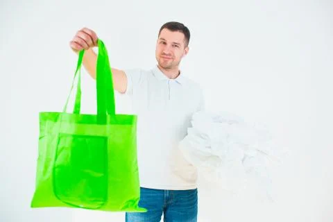 Young man isolated over white background. Guy hold green eco bag in one hand and Stock Photos