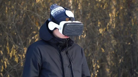 A young man in a jacket, in glasses of virtual reality against the background of Stock-Footage 85994287