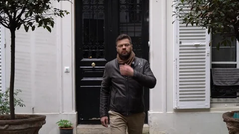 Young man in a jacket leaves the old vintage house in Paris Stock Footage 107497910