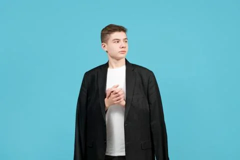 A young man in a jacket that is obviously too big is looking away Foto stock