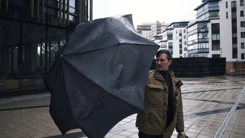 Young man in jacket with umbrella standing near the business centre building. Th Stock Footage 79415012