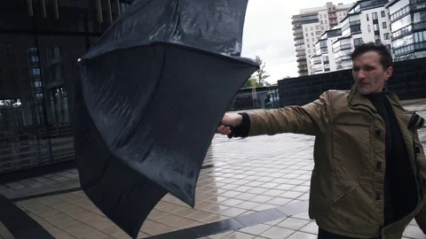 Young man in jacket with umbrella standing near the business centre building Stock Footage 79415095