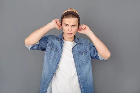 Young man in jeans jacket studio isolated on grey stylish Stock Photos