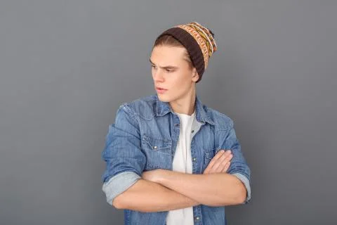 Young man in jeans jacket studio isolated on grey looking aside cool Stock Photos